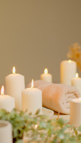 Vertical-Video-Still-Life-Of-Lit-Candles-With-Dried-Grasses-Incense-Stick-And-Soft-Towels-As-Part-Of-Relaxing-Spa-Day-Decor-3